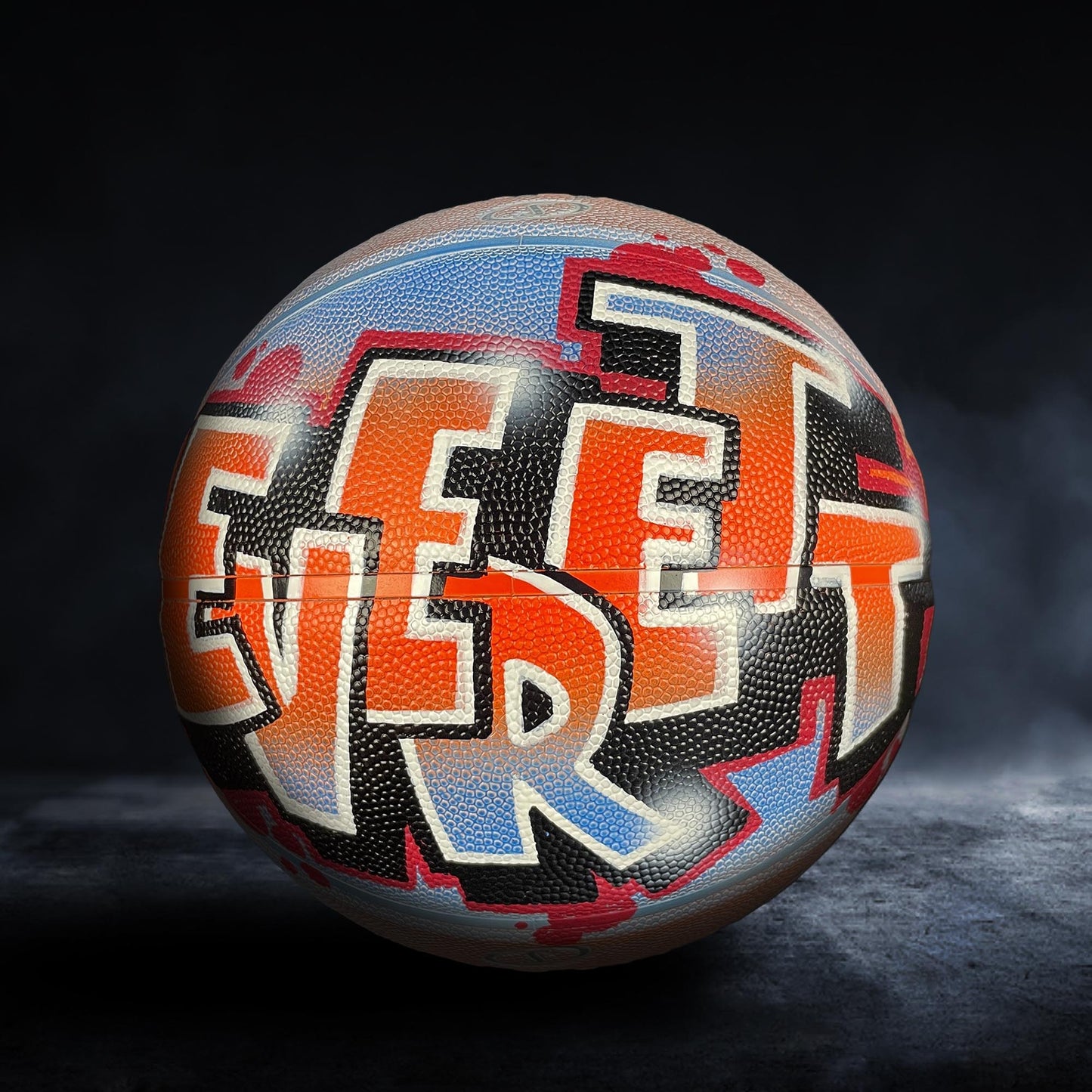 A basketball with graffiti-style text on it, which appears to be a creative and artistic design.