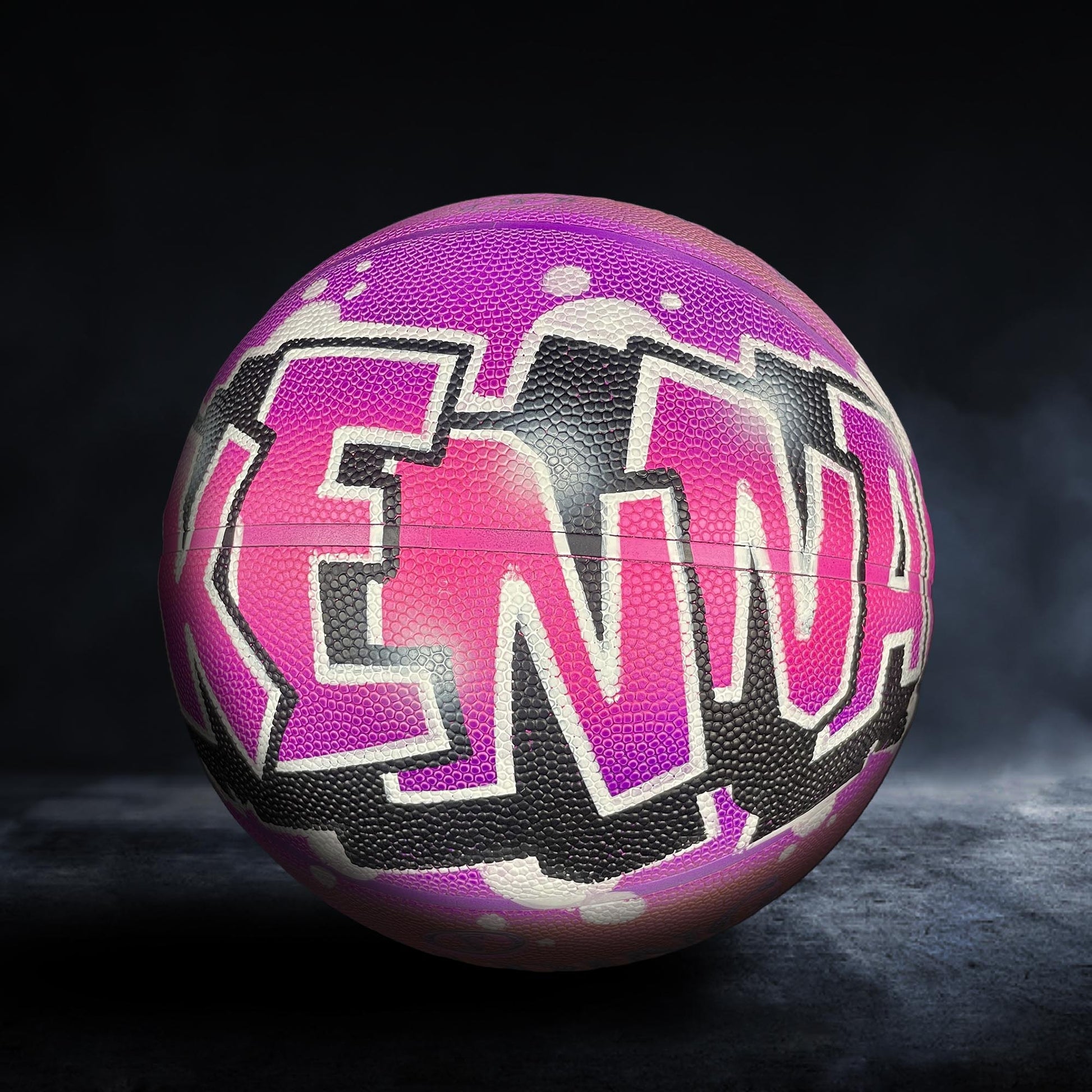 A colorful basketball with the name "KENNA" painted on it in a stylized, graffiti-like design.
