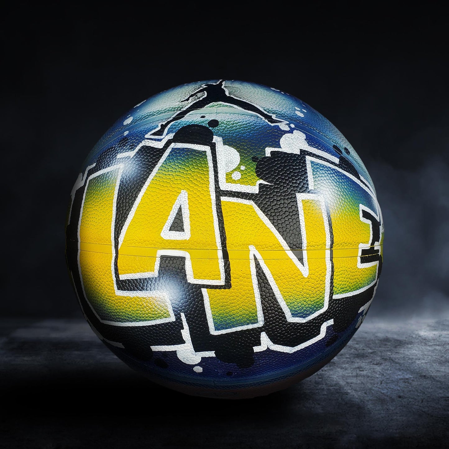 A basketball with graffiti-style lettering on it, including the word "LANE" prominently displayed.