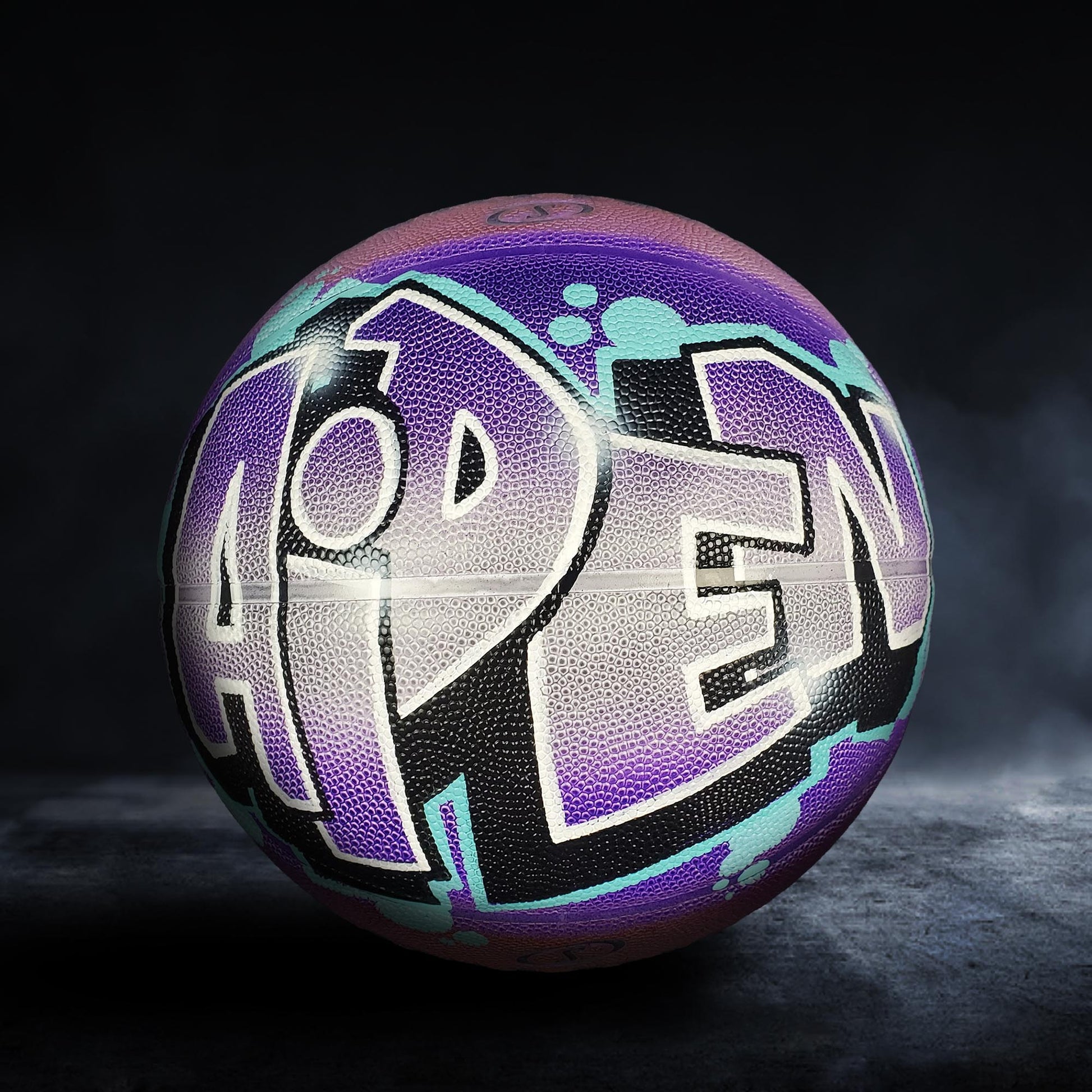 A colorful basketball with the word "OPEN" painted on it, set against a dark background.