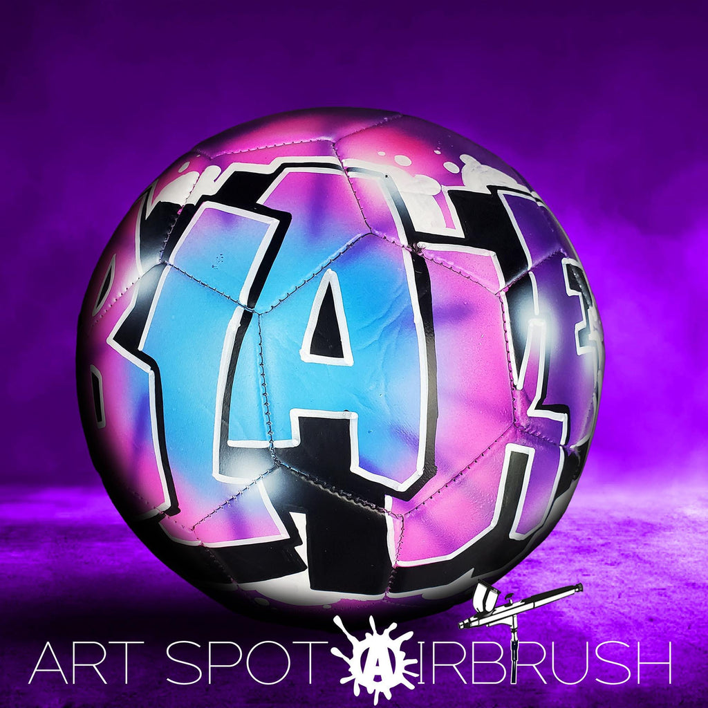 A colorful soccer ball with graffiti-style lettering on it, set against a purple background.