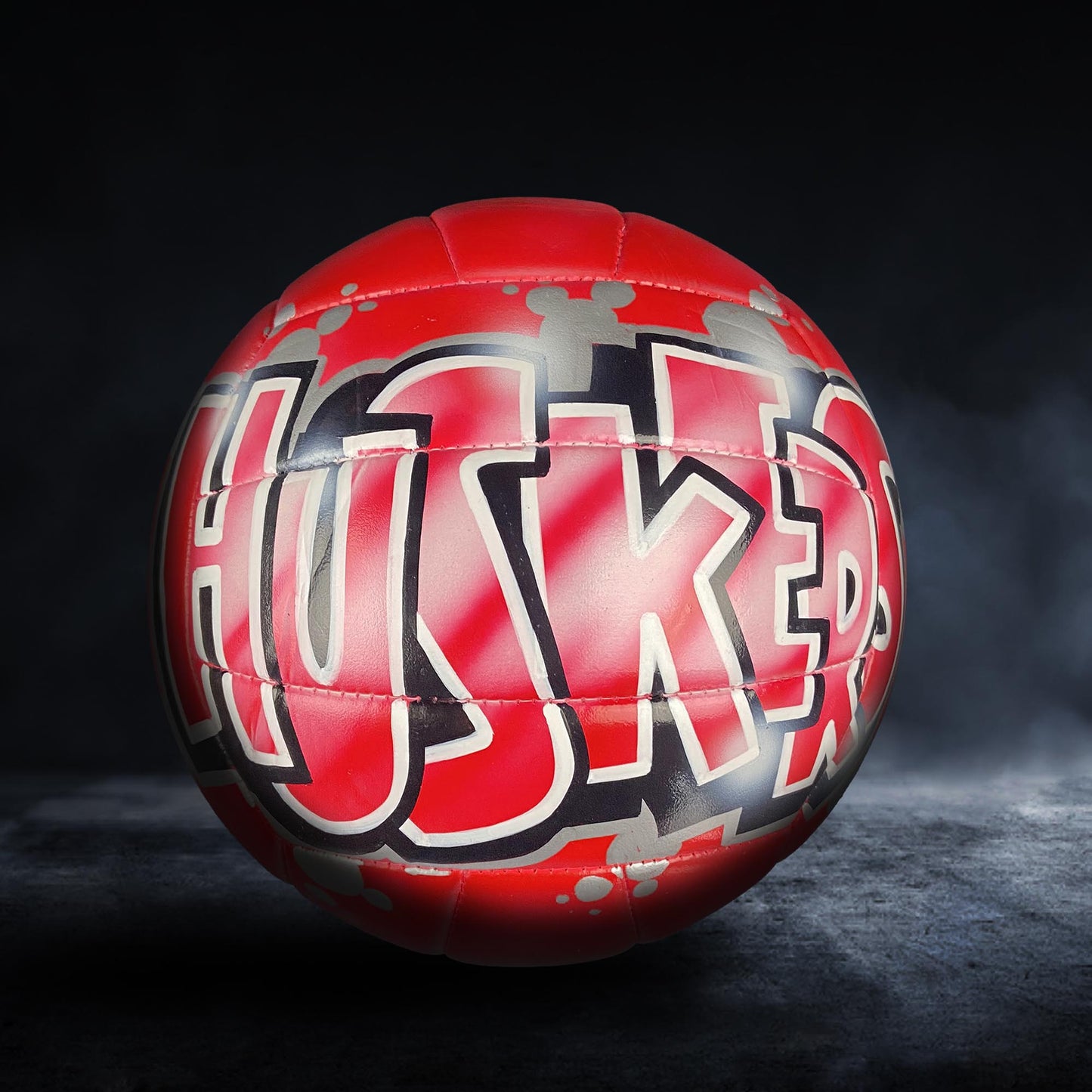 A red and black basketball with the word "HUSKIES" written on it.