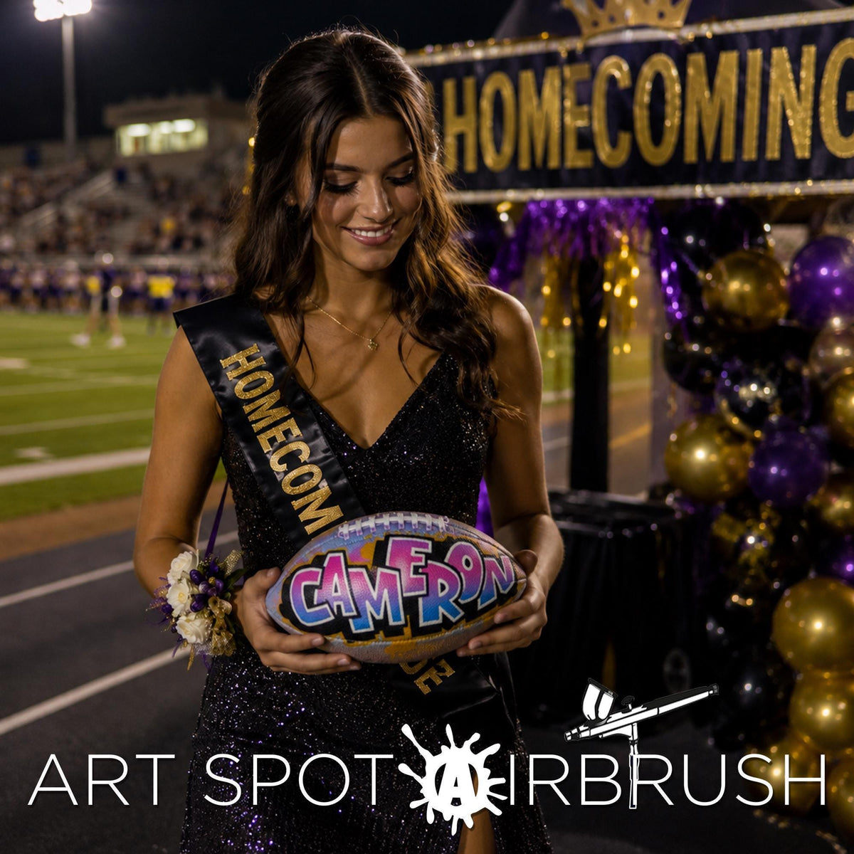 A young woman in a sparkling black dress holding a custom football, personalized with the word "CAMERON" on it, standing in front of a sign that says "HOMEOCOMING".