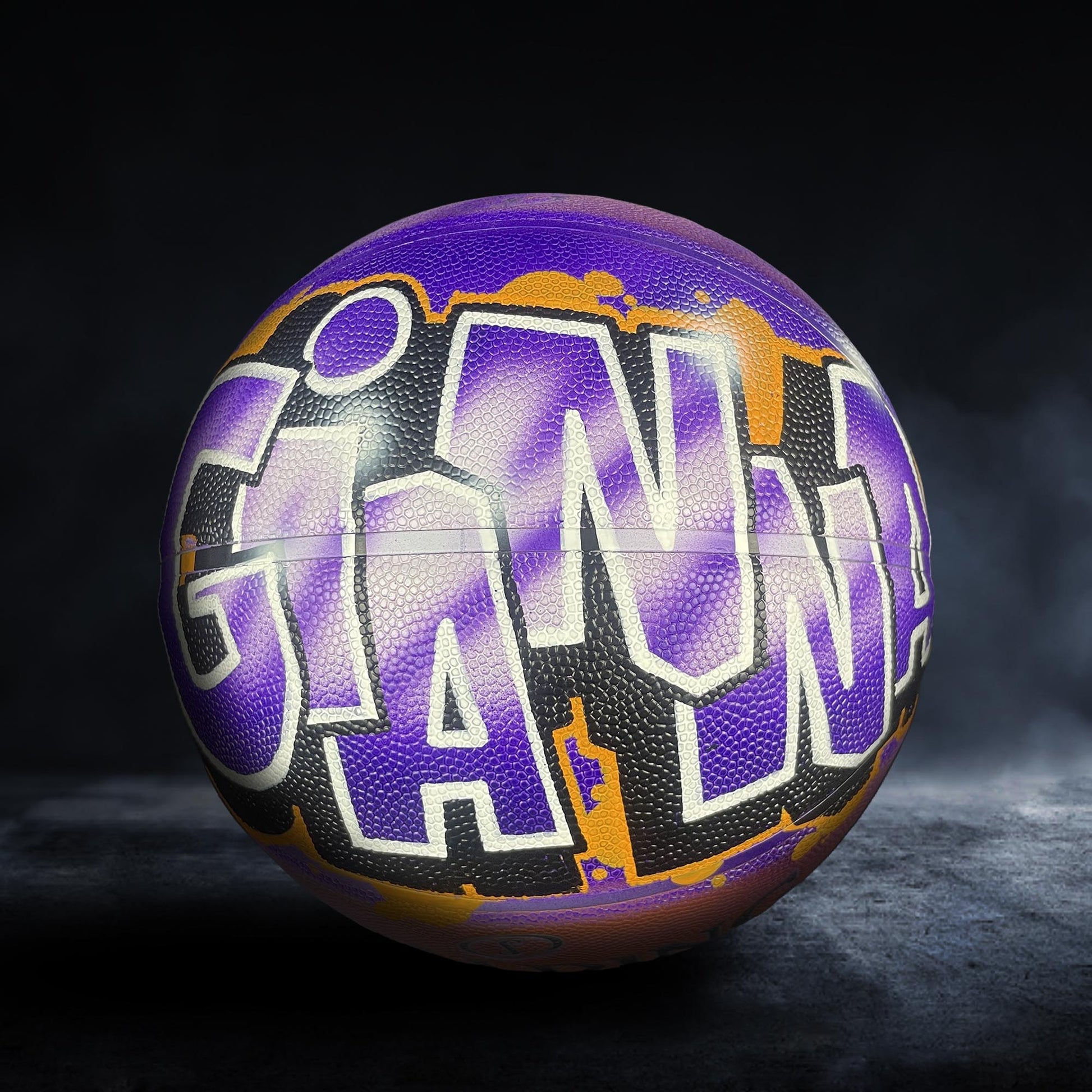 A purple and orange basketball with the word "GIANTS" written on it in a stylized font.