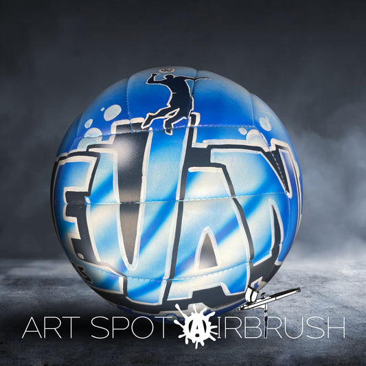 A blue and black sports ball with a graphic design on it, placed on a dark surface.